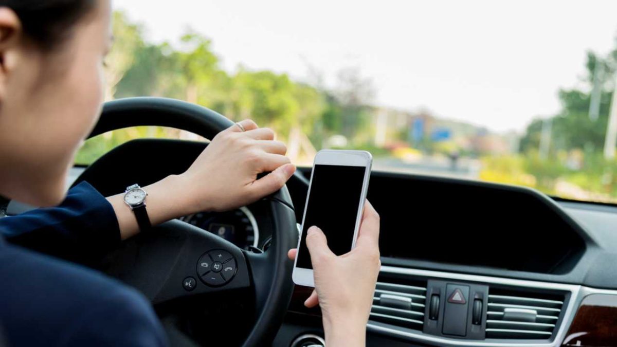 Conducente con cuffie e schermo in auto, distrazione alla guida, multe in arrivo