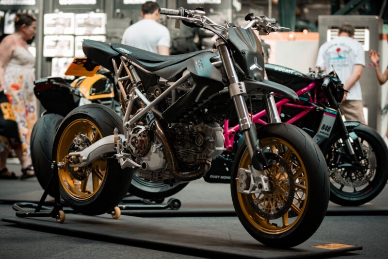 Una supermotard artigianale in alluminio, con telaio leggero e dettagli di alta precisione, esposta al Bike Shed Moto Show di Londra