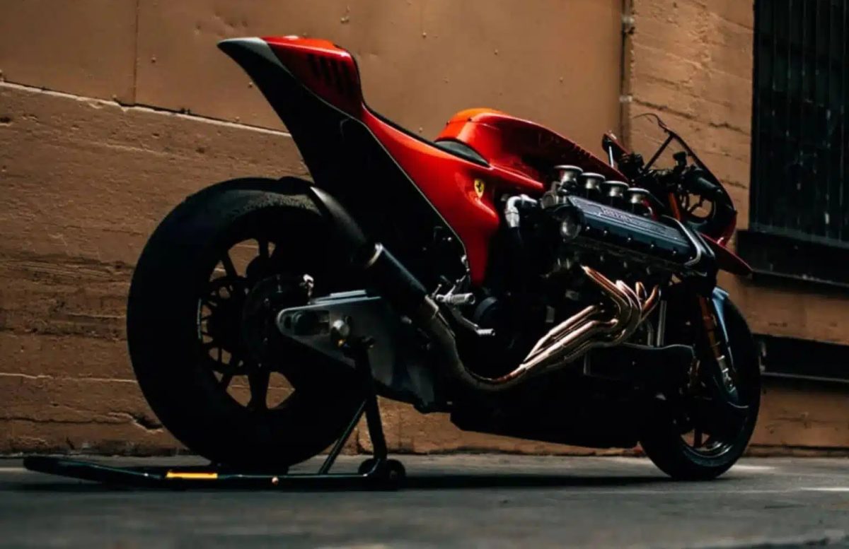 Una moto artigianale con motore Ferrari V8, colorata di rosso, in un garage, con dettagli di alta tecnologia e design moderno