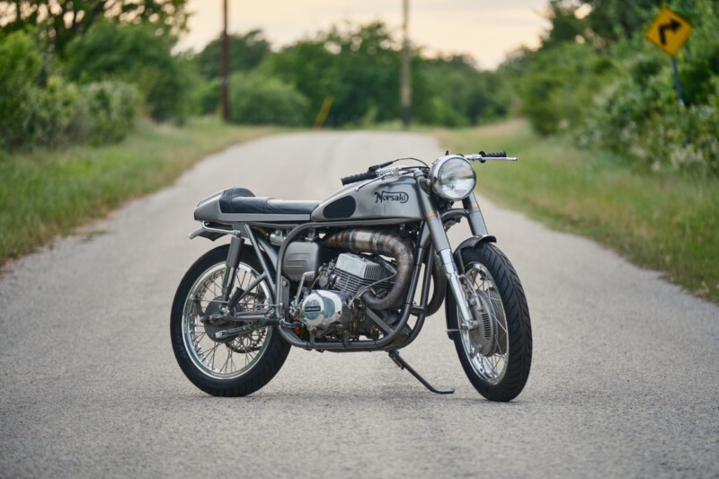 Una moto vintage con telaio Norton e motore Kawasaki, con dettagli artigianali e design unico