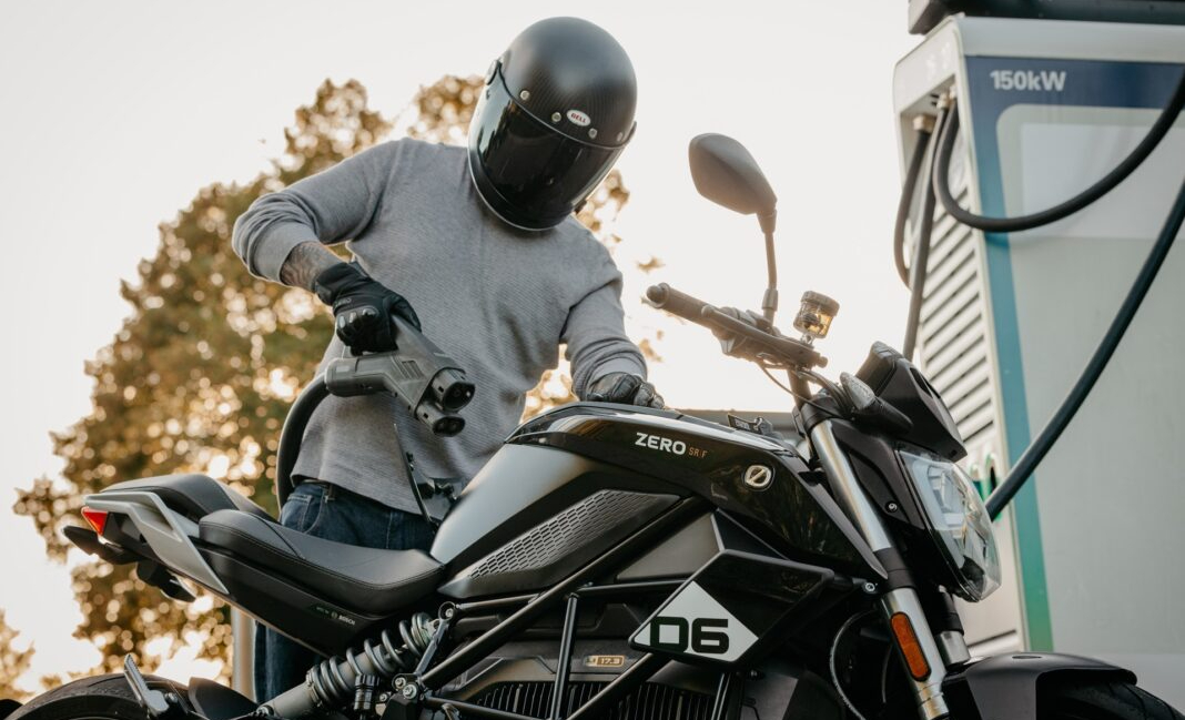 Motociclista utilizza una colonnina di ricarica rapida per una moto elettrica Zero Motorcycles, con indicatore di carica al 80%